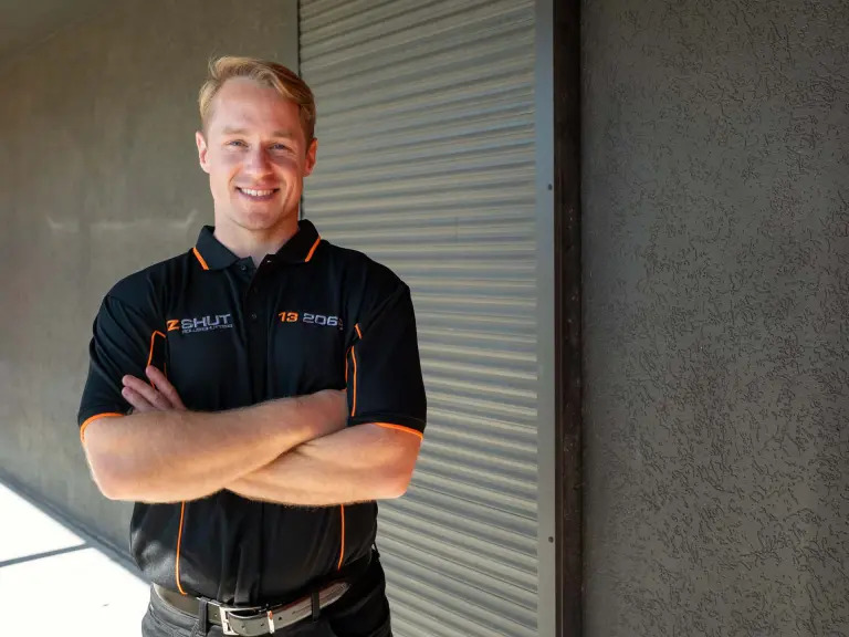 ozshut technician standing in front of roller shutters